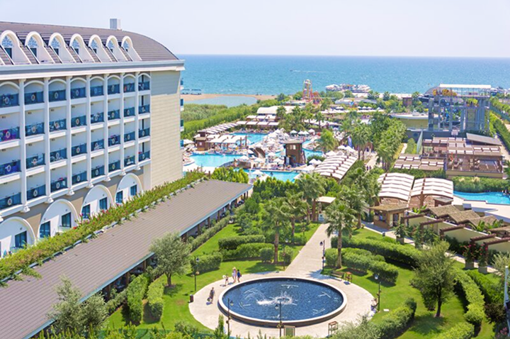 Hotelanlage mit einem einladenden Pool und einem dekorativen Brunnen im Vordergrund. Hotelanlage mit einem einladenden Pool und einem dekorativen Brunnen im Vordergrund.