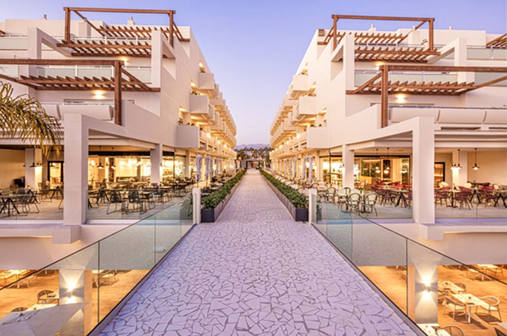 Ein schöner Weg führt zu einem Hotel, das über eine Terrasse mit Sitzgelegenheiten im Freien verfügt. Ein schöner Weg führt zu einem Hotel, das über eine Terrasse mit Sitzgelegenheiten im Freien verfügt.