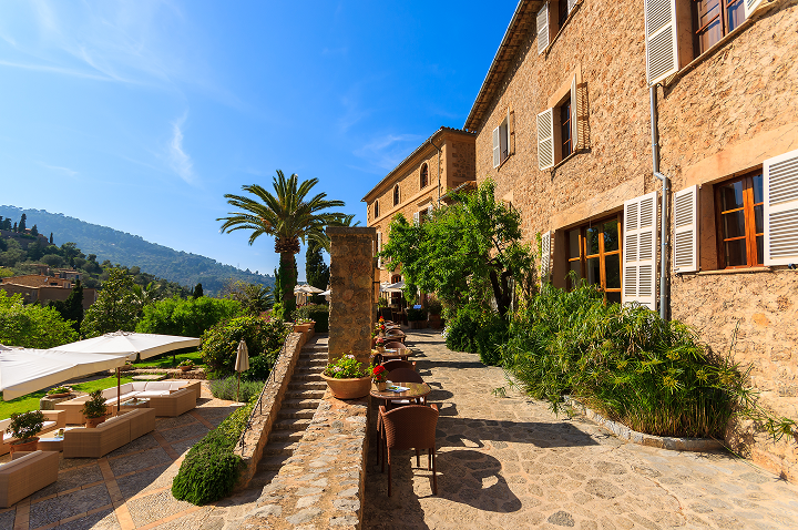 Blick auf einen Innenhof mit Terrasse und beeindruckendem Bergpanorama im Hintergrund. Blick auf einen Innenhof mit Terrasse und beeindruckendem Bergpanorama im Hintergrund.