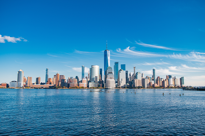 Ein ruhiges Wasser mit einer lebhaften Stadtlandschaft im Hintergrund, die den Himmel überragt. Ein ruhiges Wasser mit einer lebhaften Stadtlandschaft im Hintergrund, die den Himmel überragt.