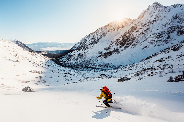 Ein Skifahrer gleitet elegant die schneebedeckte Berglandschaft hinunter, während die Sonne auf die Piste scheint. Ein Skifahrer gleitet elegant die schneebedeckte Berglandschaft hinunter, während die Sonne auf die Piste scheint.